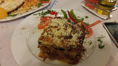 Greek tavern food (from left to right): eggplant dip, stuffed grape leaves, grilled fish, moussaka